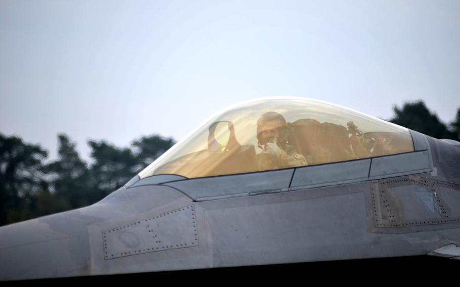 U.S. Air Force pilot of the 1st Fighter Wing signals from an F-22 Raptors while taxing towards the flight line before take-off at RAF Lakenheath, England, Thursday, October 19, 2017. Airmen of the 94th Fighter Squadron arrived earlier this month for air training missions.