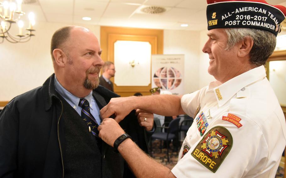 VFW Tower Post 10692 commander James Joyce, right, pins a Vietnam veteran lapel pin onto Jim Winslow in Grafenwoehr, Germany, Tuesday, Oct. 24, 2017.