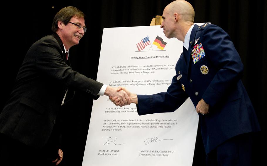 Alois Boerder, left, an Institute for Federal Real Estate representative, and Col. Jason Bailey, 52nd Fighter Wing commander, shake hands after signing a proclamation during a ceremony to turn over the Bitburg Annex housing area to the German government, on Monday, Nov. 6, 2017.