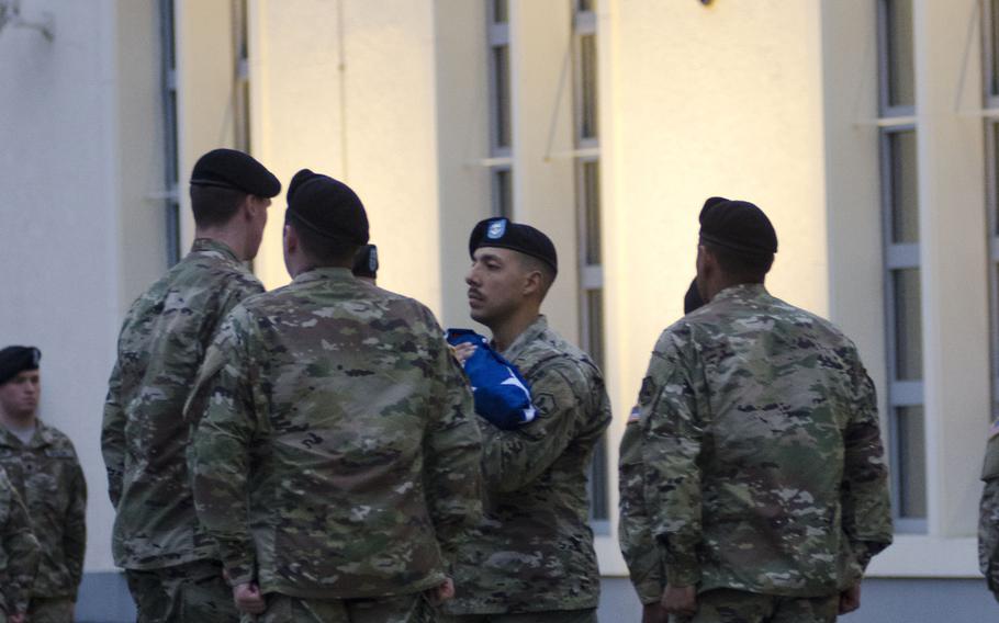 Soldiers from U.S. Army Europe fold the American flag during a Veterans Day retreat ceremony at Clay Kaserne in Wiesbaden, Germany. The German flag, which flies beside the American flag outside of USAREUR headquarters, was also folded.