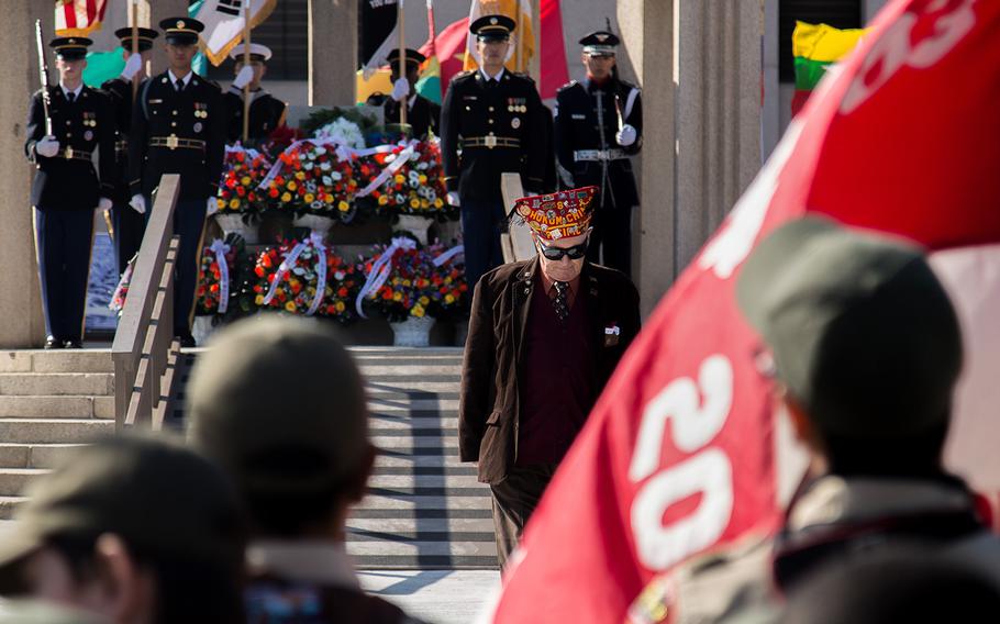 A veteran returns from laying flowers during a Veterans Day ceremony at Camp Humphreys, South Korea, Saturday, Nov. 11, 2017.