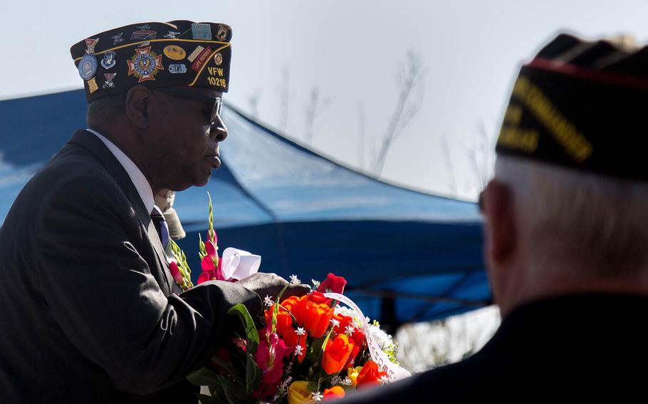 Veteran Leon Ellison lays flowers during a Veterans Day ceremony at Camp Humphreys, South Korea, Saturday, Nov. 11, 2017.