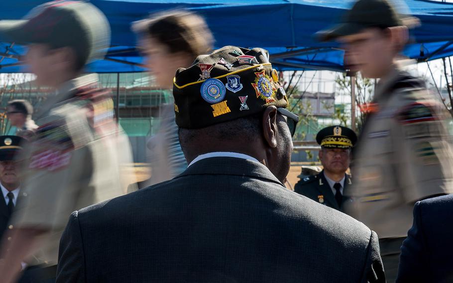 Boy Scouts walk by veterans during a Veterans Day ceremony at Camp Humphreys, South Korea, Saturday, Nov. 11, 2017.