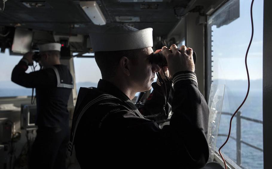 Sailors scan the horizon as the USS Ronald Reagan arrives at Yokosuka Naval Base, Japan, Monday, Dec. 4, 2017.