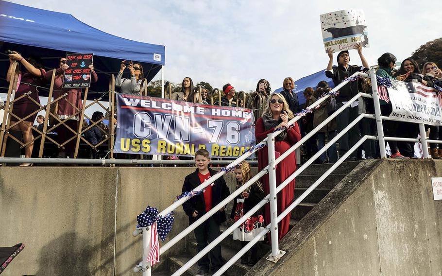 Families wait for the USS Ronald Reagan to arrive at Yokosuka Naval Base, Japan, Monday, Dec. 4, 2017.