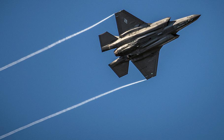 An F-35 Lightning II streaks across the sky while doing maneuvers over the Eglin Air Force Base runway. An increase in procurement of the jets accounts for part of the hike in military spending over the next decade calculated by the Congressional Budget Office.