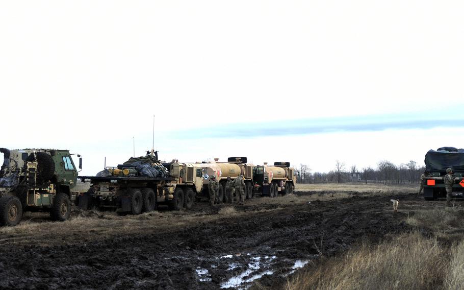 U.S. Army trucks and supplies on a muddy field during training in Smardan, Romania, Wednesday, Dec. 6, 2017.