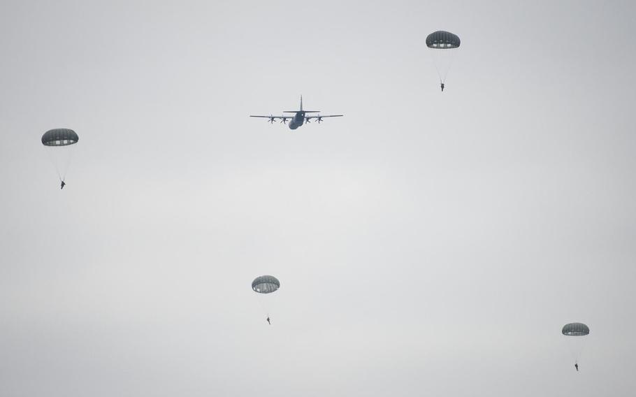 U.S. and European military personnel parachute to the ground behind a U.S. Air Force C-130 near Alzey, Germany, on Wednesday, Dec. 6, 2017.
