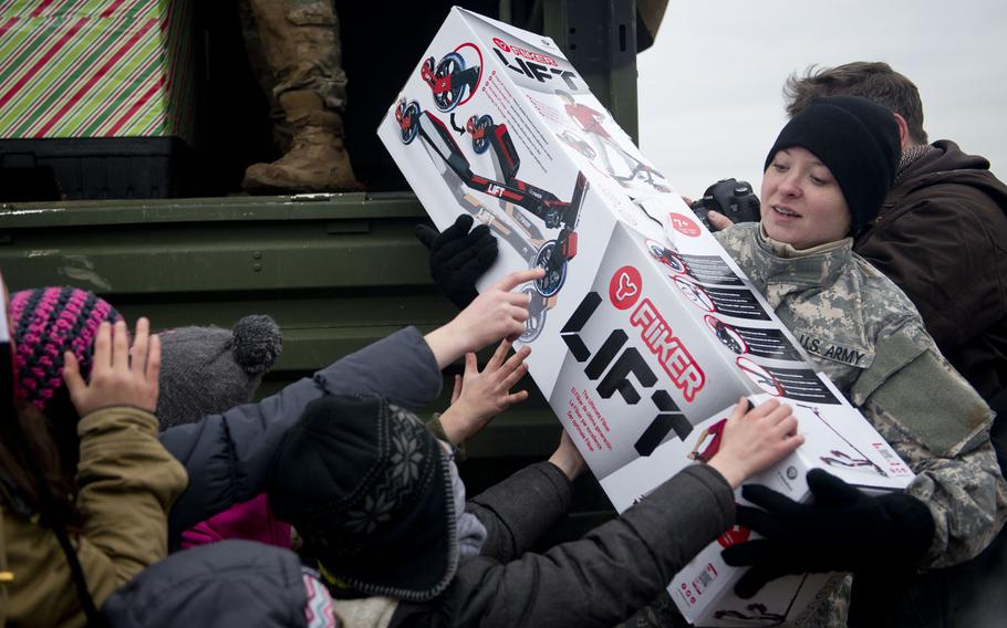 U.S. Army Sgt. Katelyn Garrett, a parachute rigger from the 5th Quartermaster Theater Aerial Delivery Company, hands out toys near Alzey, Germany, on Wednesday, Dec. 6, 2017.