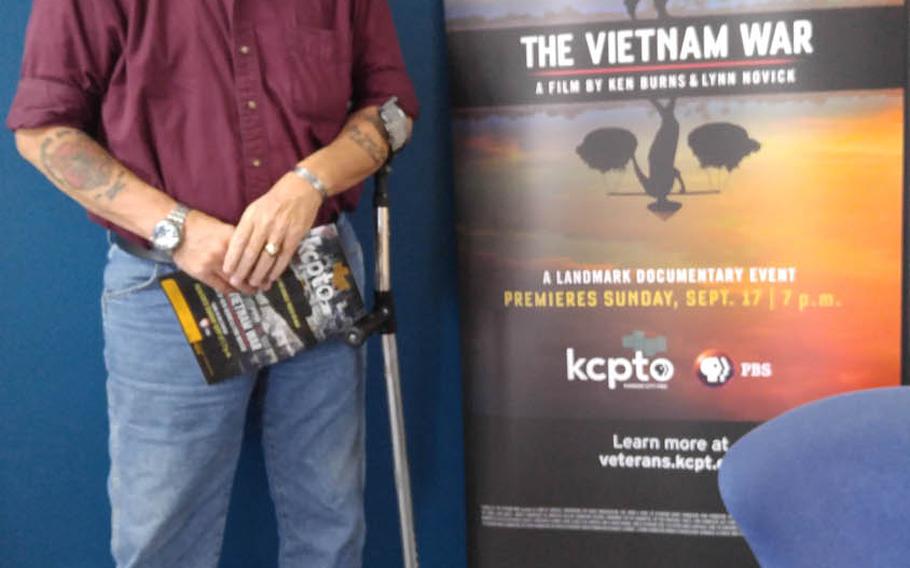 Vietnam veteran and poet John Musgrave stands in front of the poster for "The Vietnam War" documentary, in which he is featured, during a Kansas preview ahead of the film's airing on PBS in September.  Musgrave overcame severe post-traumatic stress after being shot  in the face and chest in November 1967, sustaining life-threatening and permanently disabling injuries, and now helps to counsel post-911 veterans. 
Photo courtesy of John Musgrave