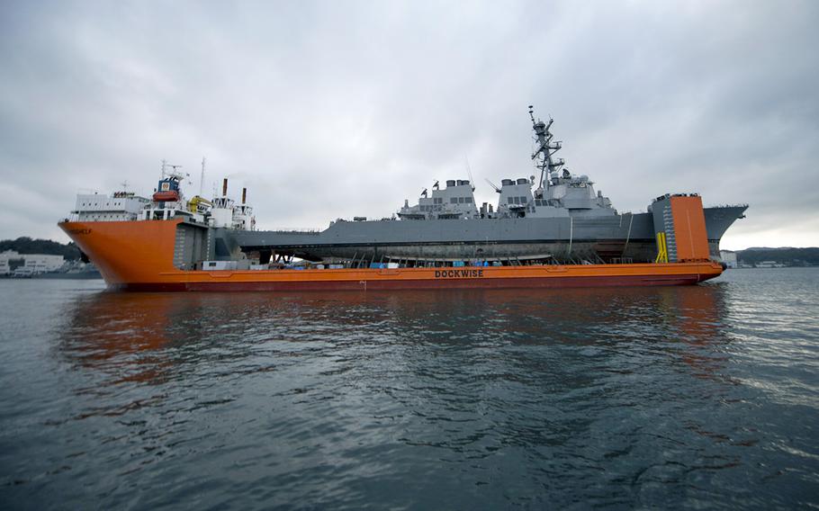 The guided-missile destroyer USS Fitzgerald leaves its berthing area at Yokosuka Naval Base, Japan, aboard the heavy lift transport vessel MV Transshelf, Dec. 1, 2017.