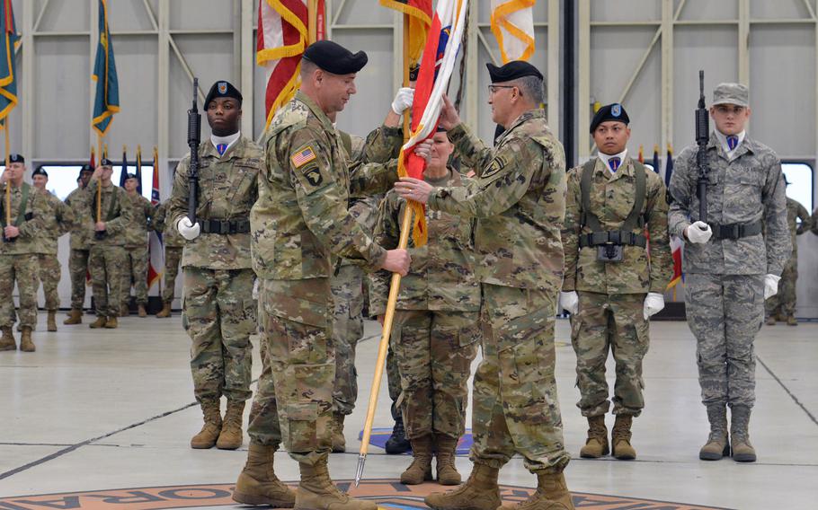 The outgoing commander of U.S. Army Europe, Lt. Gen. Ben Hodges, left, passes the unit's colors to Gen. Curtis Scaparrotti, commander of U.S. European Command, at the relinquishment of command and retirement ceremony for Hodges at Clay Kaserne in Wiesbaden, Germany, Friday, Dec. 15, 2017.