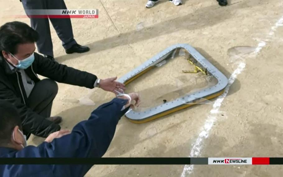 This image from an NHK broadcast shows a window from a CH-53E Super Stallion helicopter after it fell onto an elementary school sports field near Marine Corps Air Station Futenma, Okinawa, Wednesday, Dec. 13, 2017.