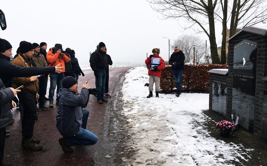 U.S. soldiers and families from the Grafenwoehr Training Area take pictures of the Company C memorial near Bastogne, Belgium, Saturday, Dec. 16, 2017.