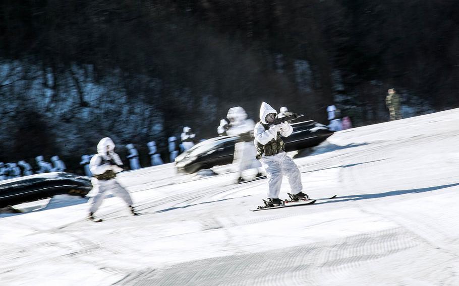 Guns in hand, South Korean troops ski down a slope at Pyeongchang, South Korea, Tuesday, Dec. 19, 2017.