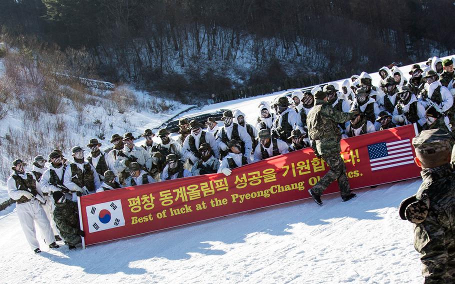 Marines from the United States and South Korea pose in front of a sign touting the upcoming Winter Games at Pyeongchang, South Korea, Tuesday, Dec. 19, 2017.
