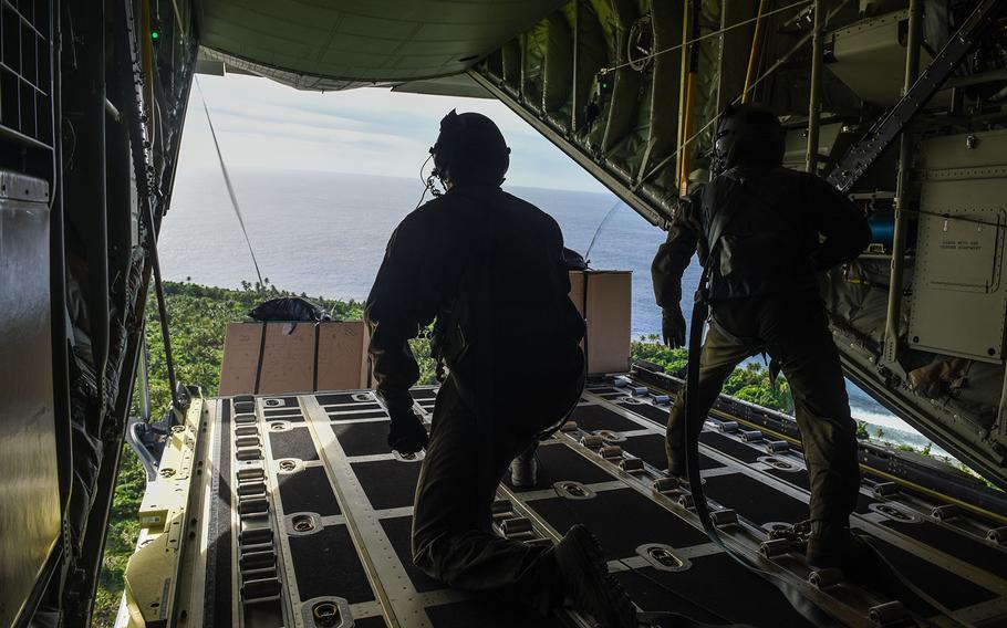 Tech. Sgt. Napoleon Ortiz, left, and Staff Sgt. Joseph Arcega, loadmasters with the 36th Airlift Squadron, push an Operation Christmas Drop bundle from the ramp of a C-130J Super Hercules, Dec. 11, 2017.
