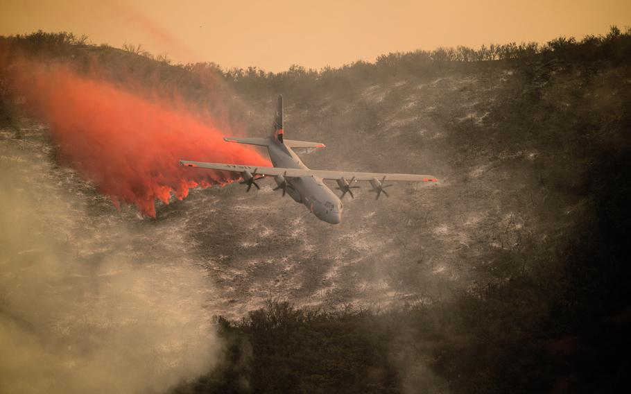 A U.S. Air National Guard C-130J Hercules aircraft equipped with the Modular Airborne Fire Fighting System drops a line of fire retardant on the Thomas Fire in the hills above the city of Santa Barbara, Calif., Dec. 13, 2017. A recent report by the GAO identifies climate change as a threat to military installations.