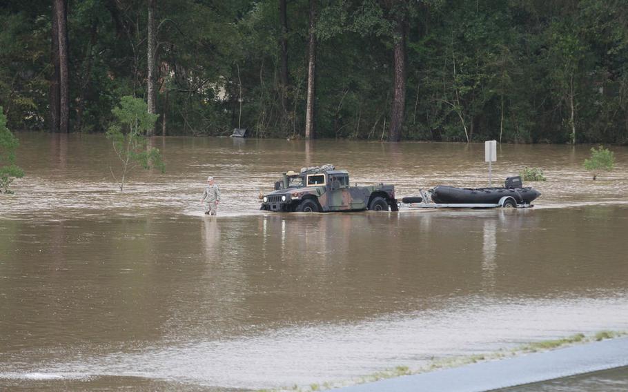 A Louisiana National Guardsman guiding a Humvee through floodwaters outside of Denham Springs after flash flooding in 2016. A recent report by the GAO identifies climate change as a threat to military installations.