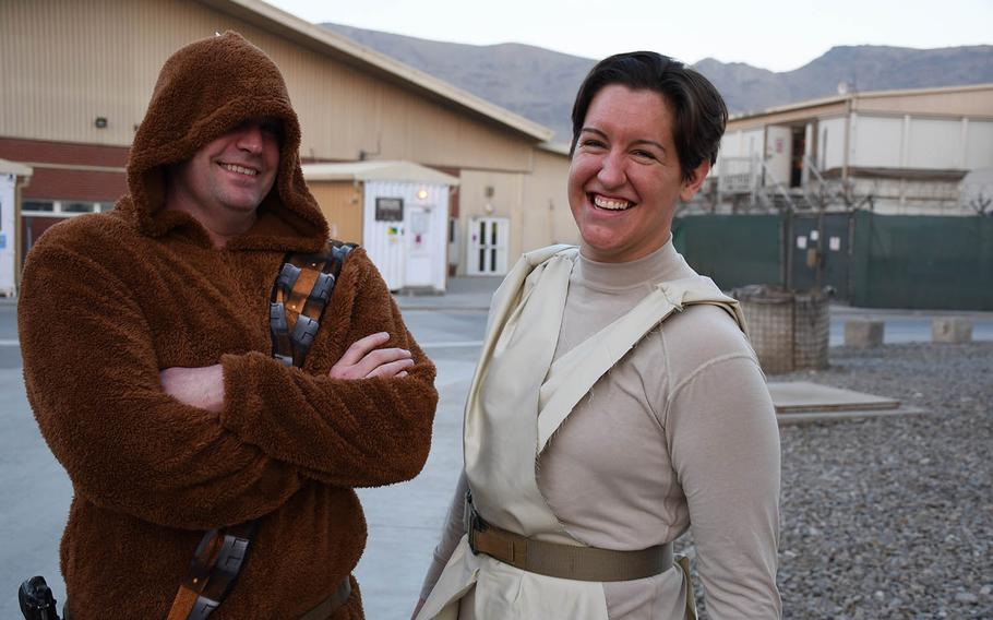 Air Force Maj. Patrick Currie, left, dressed in a Chewbacca outfit his wife sent him, and Capt. Madison Scaccia, in a Rey costume she made out of issued gear and a swatch of cloth from the base bazaar, wait in line for a for a screening of "Star Wars: The Last Jedi" at a coalition base in Kabul, Afghanistan, on Saturday, Dec. 23, 2017.