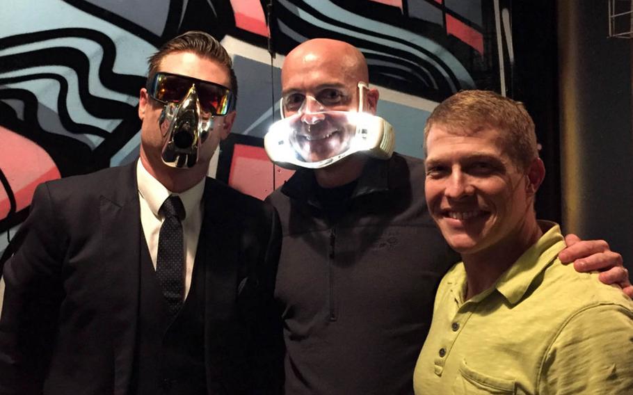 Dan Bowden, left, CEO of the high-tech startup O2O2, and Cmdr. Tom Ogden don prototype facemasks the company is developing in Auckland, New Zealand.  Lt. Cmdr. Derek Fletcher, right, recently spent five weeks at the company evaluating the product's potential uses on Navy flight decks.