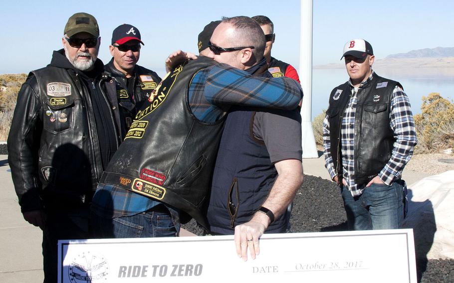 Ryan Fleischman, a member of the Combat Veterans Motorcycle Association, hugs psychologist Craig Bryan after awarding Bryan and the National Center for Veterans Studies $35,000 for suicide prevention. The association concluded its annual Ride to Zero initiative Saturday, Oct. 28 at Antelope Island State Park in Utah.