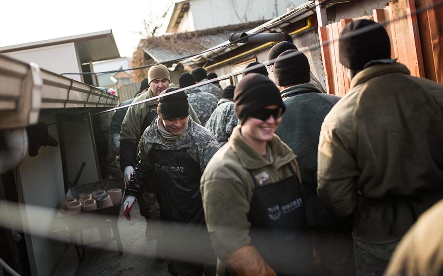 Soldiers from 1st Battalion, 38th Field Artillery Regiment carry charcoal briquettes to local homes in Yeoncheon, South Korea, Thursday, Dec. 28, 2017.