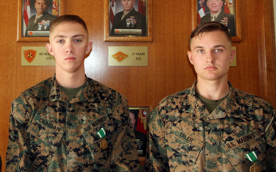 Marine Sgt. Justin Erler and Cpl. Matthew Dungan pose after receiving the Navy and Marine Corps Commendation Medal at Camp Courtney, Okinawa, Wednesday, Jan. 3, 2018.