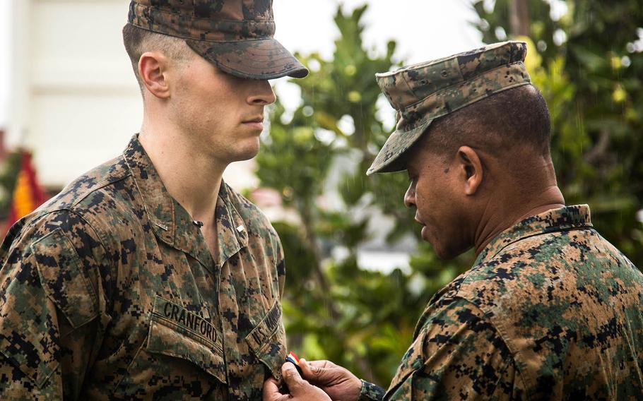 Marine 1st Lt. Aaron Cranford receives the Navy and Marine Corps Medal from Maj. Gen. Craig Timberlake, 3rd Marine Division commander, at Camp Schwab, Okinawa, Monday, Jan. 8, 2018.