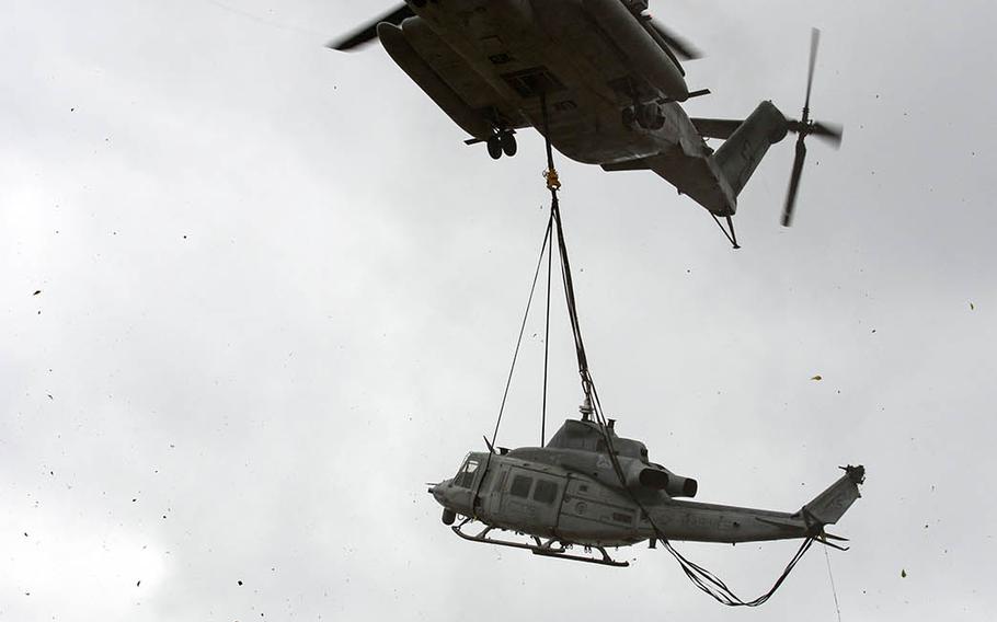 Marines with Heavy Marine Helicopter Squadron 466 lift a UH-1Y Venom after it made a precautionary landing in Okinawa, Japan, Monday, Jan. 8, 2018.