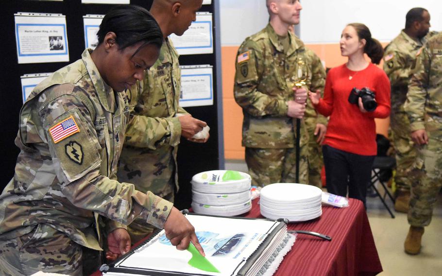 Equal opportunity adviser Sgt. 1st Class Altissa Butler cuts a cake at a ceremony in Vilseck, Germany, marking Martin Luther King's birthday, Thursday, Jan. 11, 2017.