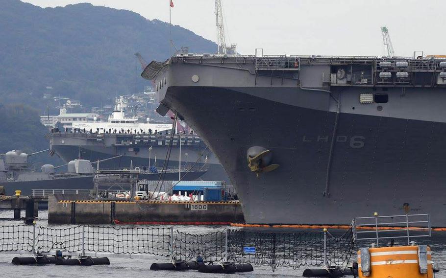 The amphibious-assault ship USS Wasp, background, pulls into Sasebo Naval Base, Japan, beside the USS Bonhomme Richard, Sunday, Jan. 14, 2018.