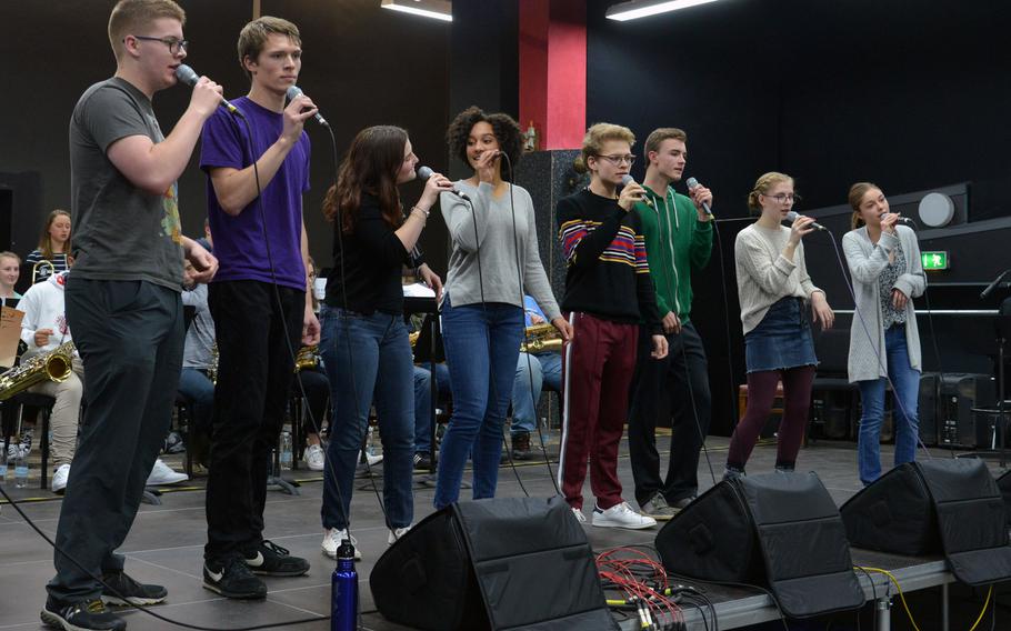 The vocal ensemble rehearses with the big band during a session at this year's DODEA-Europe jazz seminar in Ramstein, Germany, Tuesday, Jan. 16, 2018. From left are Michael Bramhall, John Rowberry, Olivia Schmitz, Lydia Woodfork, Elliot Lavis, Grady Gallagher, Violet Bender and Aubrey Armstrong. Twenty-four musicians and eight vocalists from eight high schools participated in the annual event.