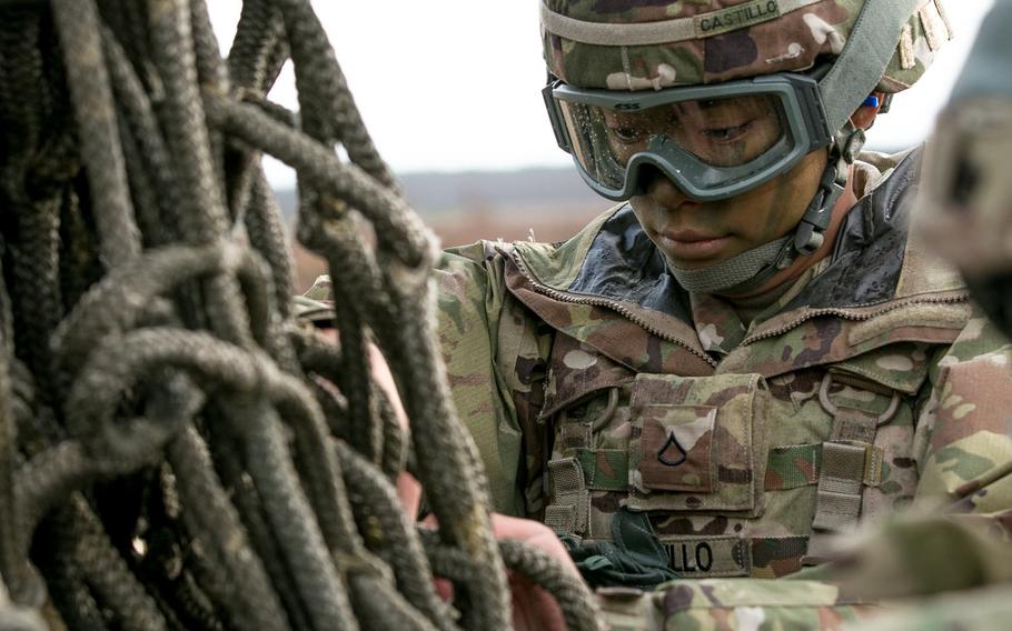 Pvt. Adrianne Castillo, automated logistics specialist with 299th Brigade Support Battalion, 2nd Brigade Combat Team, 1st Infantry Division, Fort Riley, Kan., inspects a rope harness while preparing equipment to be sling loaded from a helicopter at Skwierzyna, Poland, on Jan. 4, 2017.