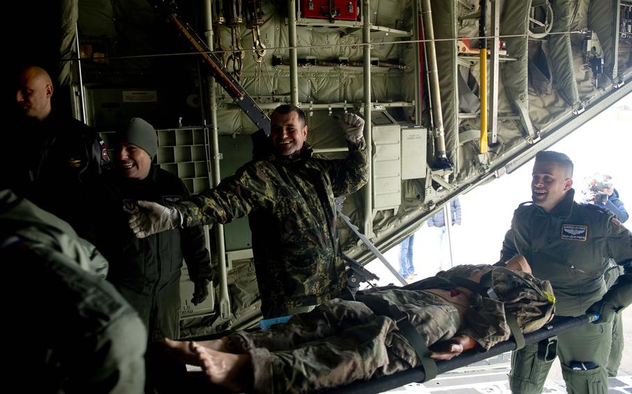 Albanian airmen load a simulated casualty onto a C-130J during a training scenario at Ramstein Air Base, Germany, on Thursday, Jan. 18, 2018.