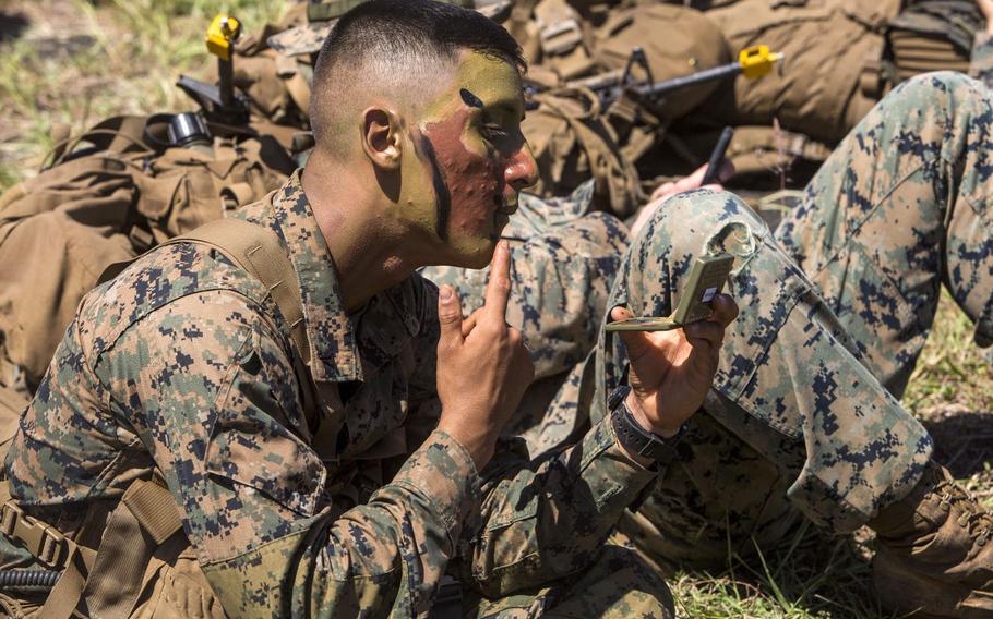 Lance Cpl. Isaac Lopez, an assaultman with 3rd Battalion, 3rd Marine Regiment, puts on camouflage paint during a Marine Corps Combat Readiness Evaluation at Marine Corps Air Station Kaneohe Bay, Oct. 3, 2017.