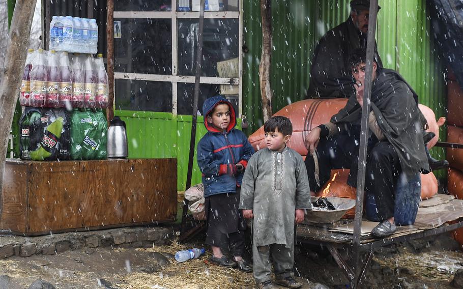 A group of Afghans huddle near a fire at a marketplace in Kabul province, Afghanistan, during a snow flurry on Monday, Jan. 29, 2018. The country has received little precipitation this winter, normally its wet season, which has concerned Afghans dependent on rain and snow for a bountiful crop.