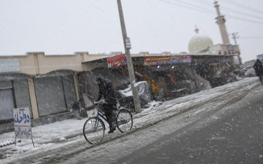 A man rides a big through a snow flurry on Monday, Jan. 29, 2018 in Kabul province, Afghanistan.