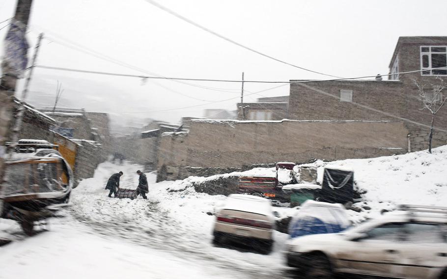 Two boys drag a carpet up a snowy hill on Monday, Jan. 29, 2018 in Kabul, Afghanistan.