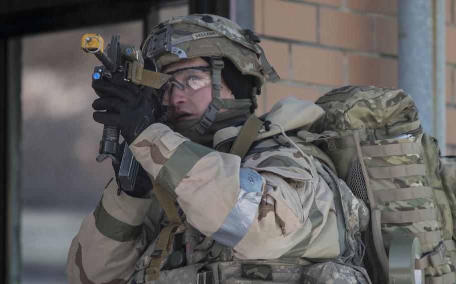 Sgt. Daviel Sellers, 1st Battalion, 9th Cavalry Regiment, 2nd Armored Brigade Combat Team, 1st Cavalry Division, scans for rooftop snipers before entering a building during a Warrior Strike drill last month.