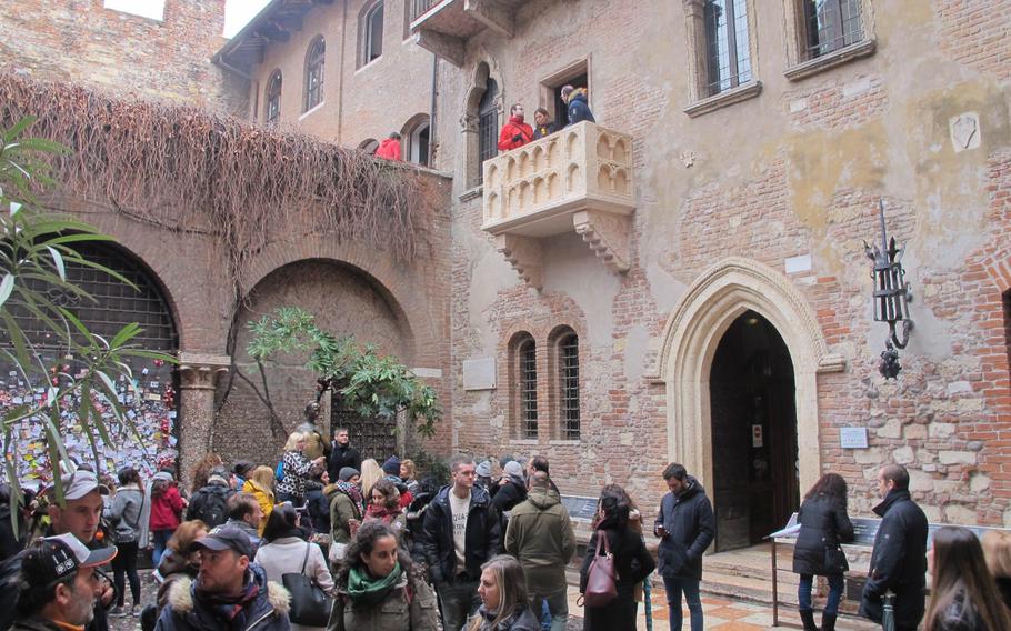 A crowd in the courtyard of Juliet's house, complete with balcony added for ambience in Verona, Italy, where Shakespeare set "Romeo and Juliet." Visitors cluster around Juliet's statue for photos. The house, one of the city's top tourist attractions, is less than an hour's drive from Vicenza.