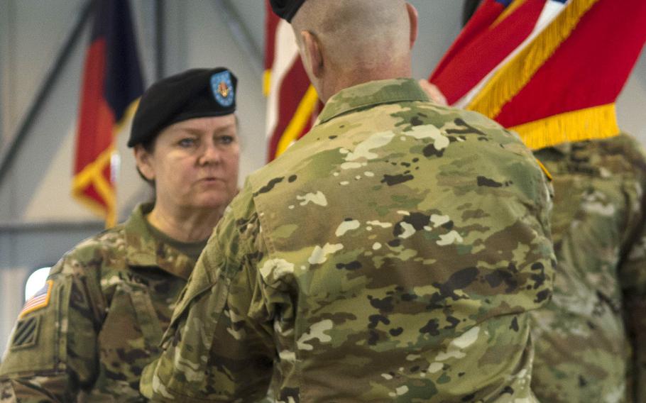 Command Sgt. Maj. Sheryl Lyon, left, passes the U.S. Army Europe colors to Lt. Gen. Christopher Cavoli, USAREUR commander, during her relinquishment of responsibility ceremony Tuesday, Feb. 20, 2018 in Wiesbaden, Germany. Lyon, who has an intelligence background, will next be taking an assignment at U.S. Army Cyber Command at Fort Belvoir, Va.