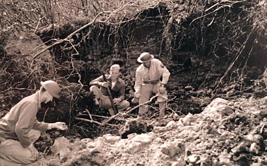Soldiers inspect a crater left near Honolulu after a Japanese bombing raid on Hawaii, March 4, 1942, in this undated photo on display at the Pacific Aviation Museum in Honolulu.