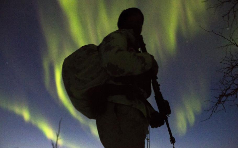 Marine with Marine Rotational Force-Europe prepares to conduct a mountainous assault on enemy position as the Northern Lights shine above during the field training exercise portion of Exercise White Claymore near Bardufoss, Norway, Feb. 15, 2018.