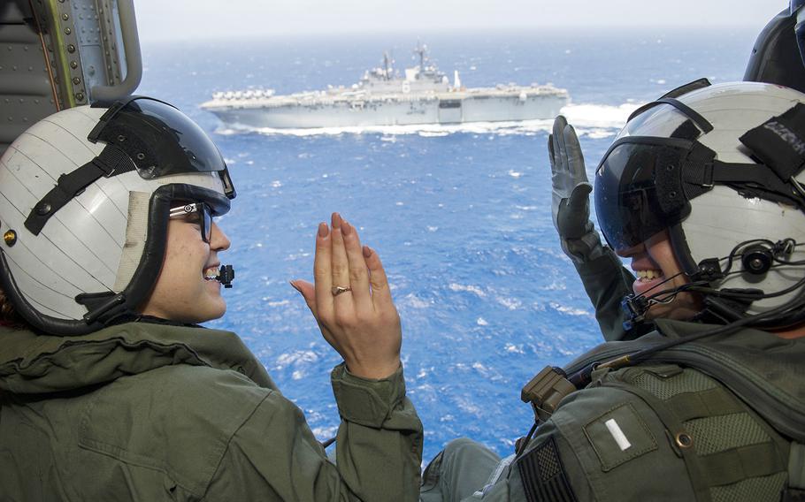 Petty Officer 3rd Class Sierra Rivera, left, of the amphibious assault ship USS America, repeats the oath of enlistment to Lt. j.g. Nicholas Haan aboard an MH-60 Sea Hawk helicopter.