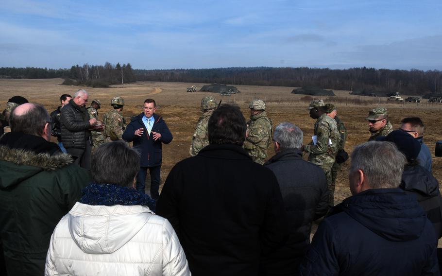 U.S. Army spokesman Andre Potzler speaks to a crowd of local, German mayors and community leaders while they watch artillery fire during exercise Dynamic Front, at Grafenwoehr, Germany, Monday, March 5, 2018. 
