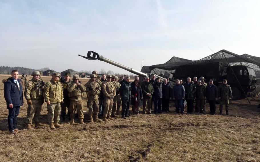 German mayors and community leaders and U.S. and German Army soldiers pose together during their visit on base to watch artillery fire during exercise Dynamic Front, at Grafenwoehr, Germany, Monday, March 5, 2018.