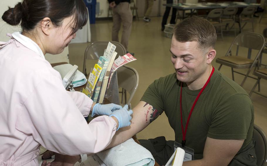 Marine Cpl. Joseph Butler, an aircraft recovery crewmember with Headquarters and Headquarters Squadron, receives a hemoglobin test before donating blood at Marine Corps Air Station Iwakuni, Japan, Tuesday, March 6, 2018.