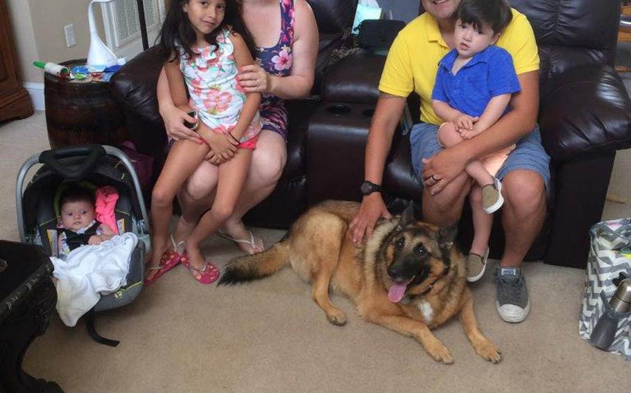 National Guardsman and former dog handler Julio Munoz, left, and his wife Shulammite, right with their children, and tactical explosives detection dog Ben during a visit to the home of Ben's adopted owner Kim Scarborough in August 2017. Scarborough sought to reunite the two after she adopted Ben from the Army in 2014