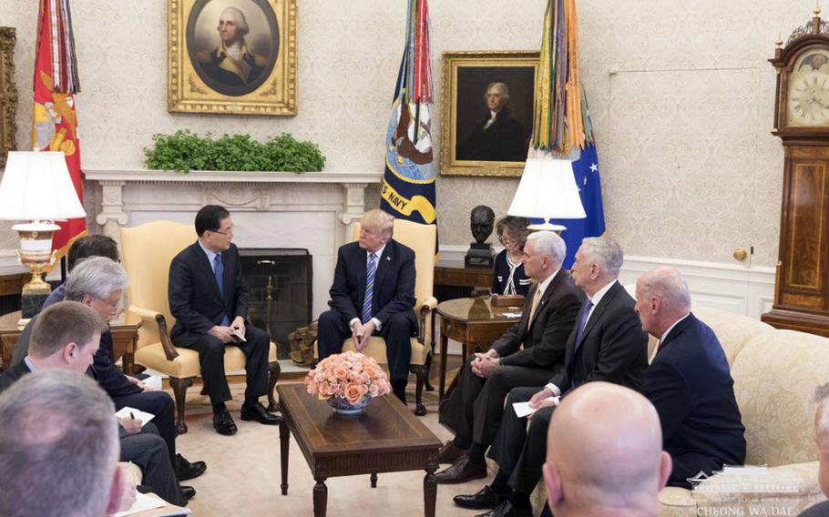 South Korean National Security Adviser Chung Eui-yong, left, speaks to President Donald Trump at the White House in the company of other U.S. and South Korean officials, Thursday, March 8, 2018.